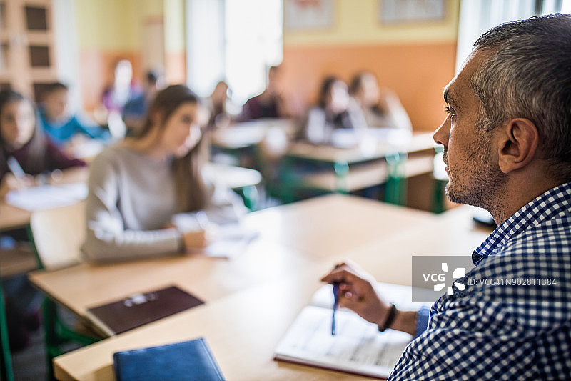 上课中的中年高中老师侧面照图片素材