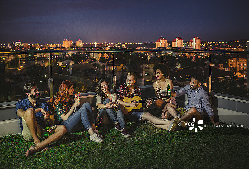 在顶层露台上与朋友们度过无忧无虑的夜晚图片素材