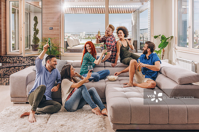 一群无忧无虑的朋友在客厅的家庭派对上玩耍图片素材