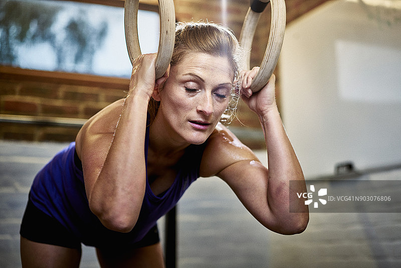 在车库改造的家庭健身房锻炼后疲惫的女人图片素材