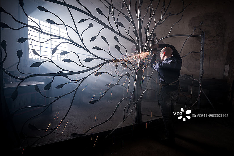 铁匠艺术家在他的铁匠工作室里制作门树图片素材
