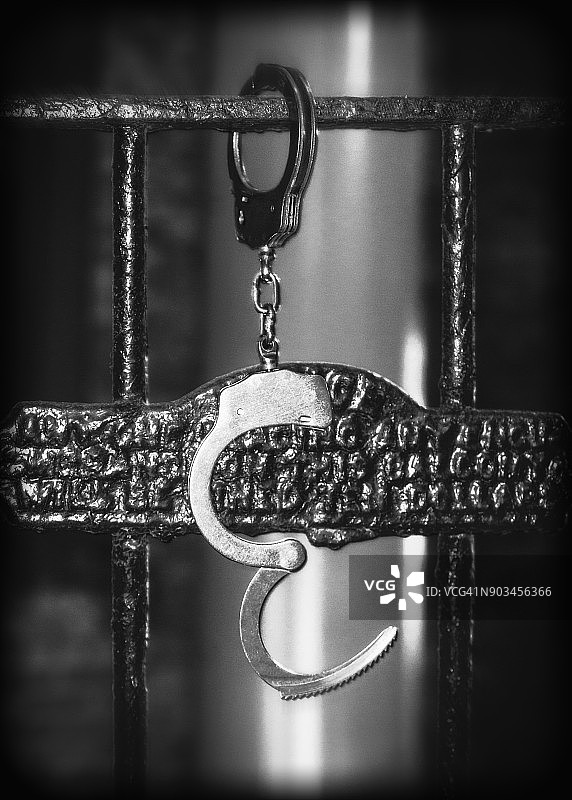 挂在栏杆上的打开的手铐图片素材
