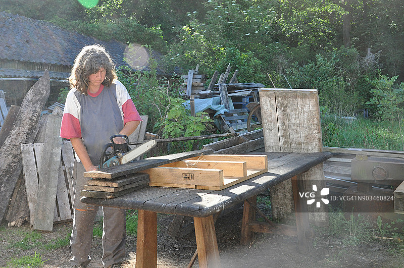 DIY，女人在花园里切割木板图片素材