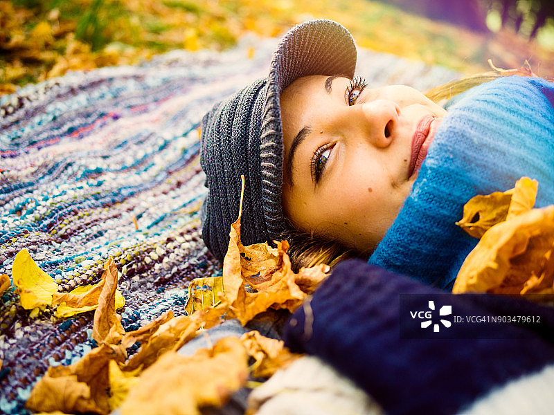 躺在公园格子布上做梦的年轻女子图片素材