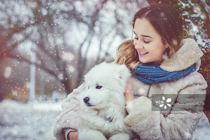 女孩和她的狗一起享受冬天图片素材