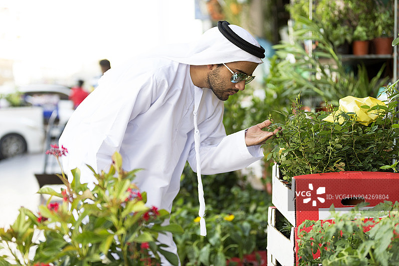 阿拉伯男人在商店里为他的花园挑选植物图片素材