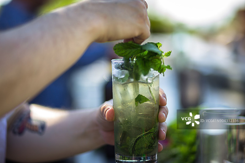 调酒师调制薄荷装饰的鸡尾酒图片素材