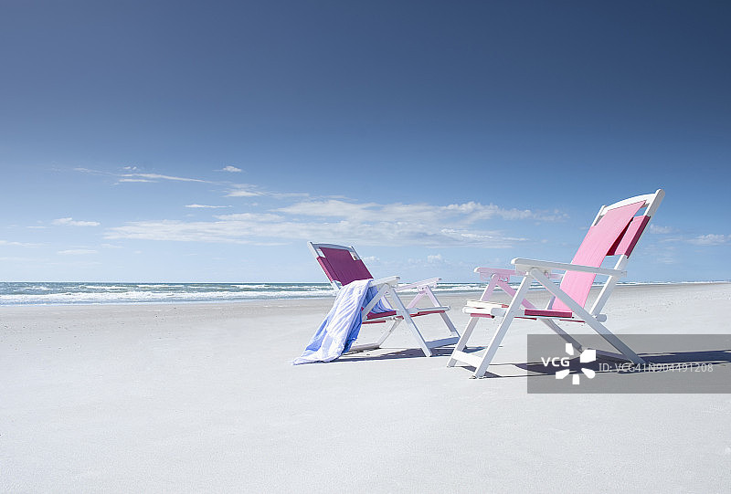 空旷海滩上的两张躺椅图片素材