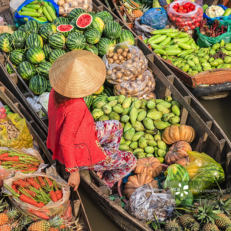 在越南湄公河三角洲水上市场卖水果的越南妇女图片素材