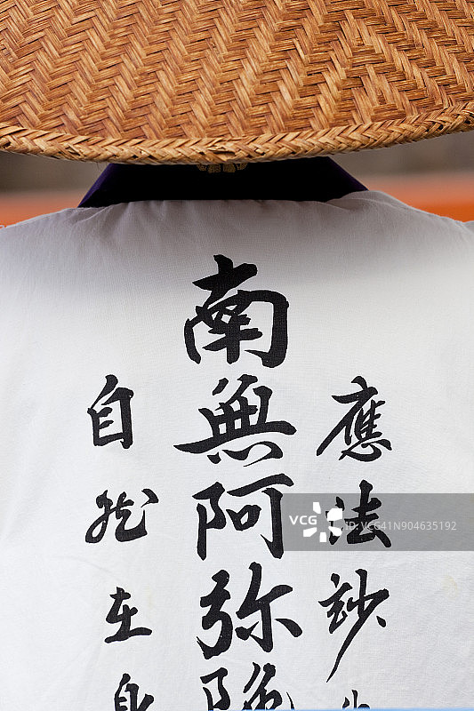 穿着传统服装和草帽的佛教尼姑背影图片素材