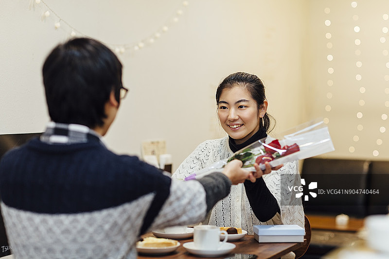 男朋友在咖啡馆给女朋友送花图片素材