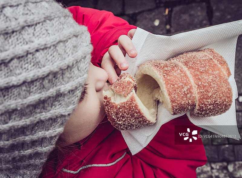 小女孩在布拉格吃Trdelnik的特写图片素材