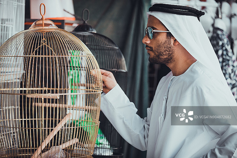 挑选鸟笼的阿拉伯男子图片素材