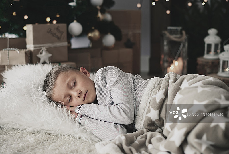 睡在地毯上的可爱男孩图片素材