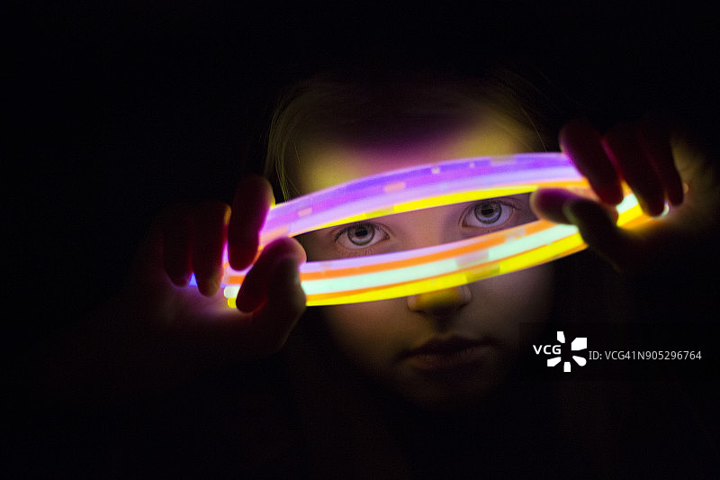 女孩透过发光棒向外看图片素材