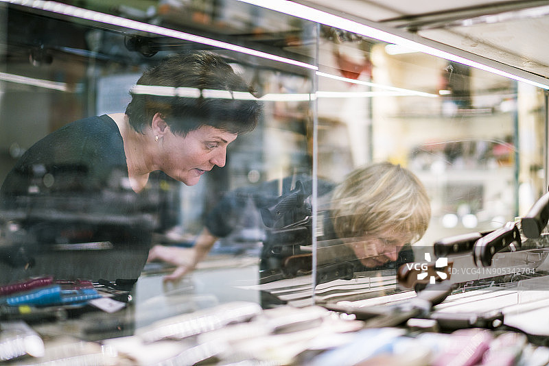 在店面观看刀具收藏的两名中年妇女图片素材