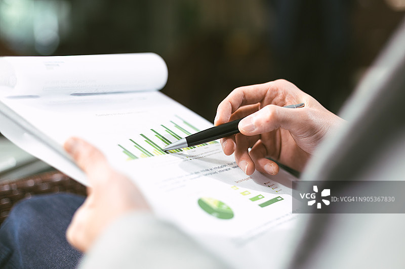 年轻的亚洲男子查看商业报告图片素材