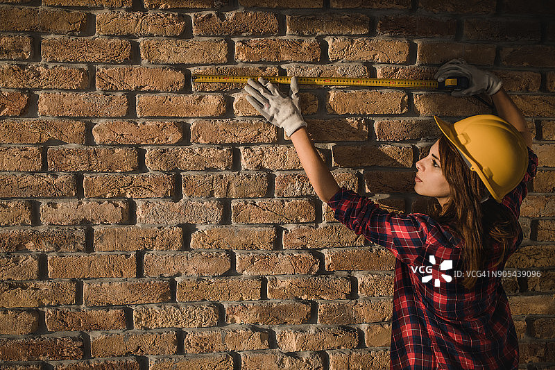 装修过程中测量干墙的女工人图片素材