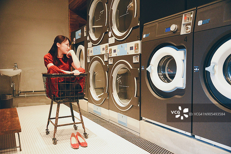 在自助洗衣店的年轻女人图片素材