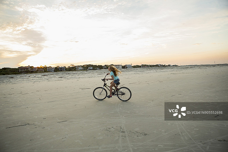 白人女孩在海滩骑自行车图片素材