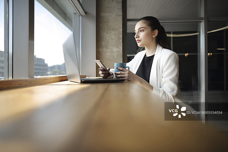 白人女性喝咖啡并用手机发短信图片素材