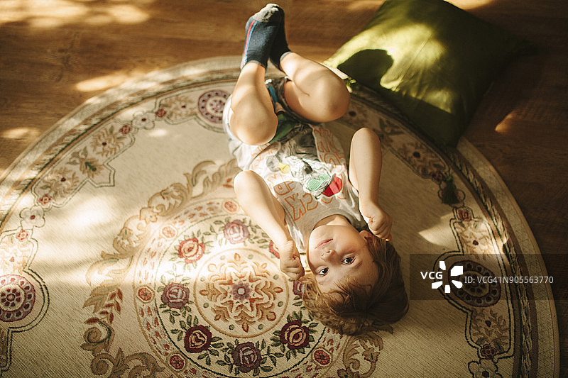 白人男孩躺在地毯上图片素材