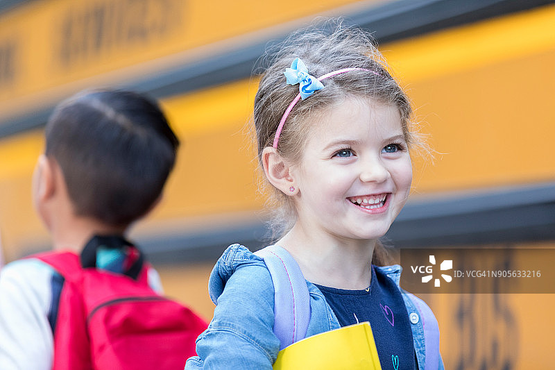 小女孩期待登上她的校车图片素材