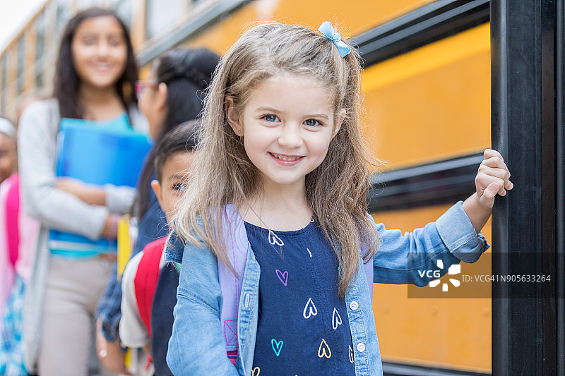 可爱的幼儿园女孩登上校车图片素材