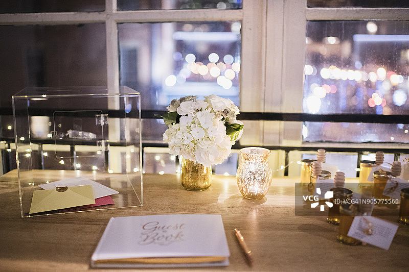 周年派对场景——木桌上的白色题词簿和玫瑰金笔图片素材