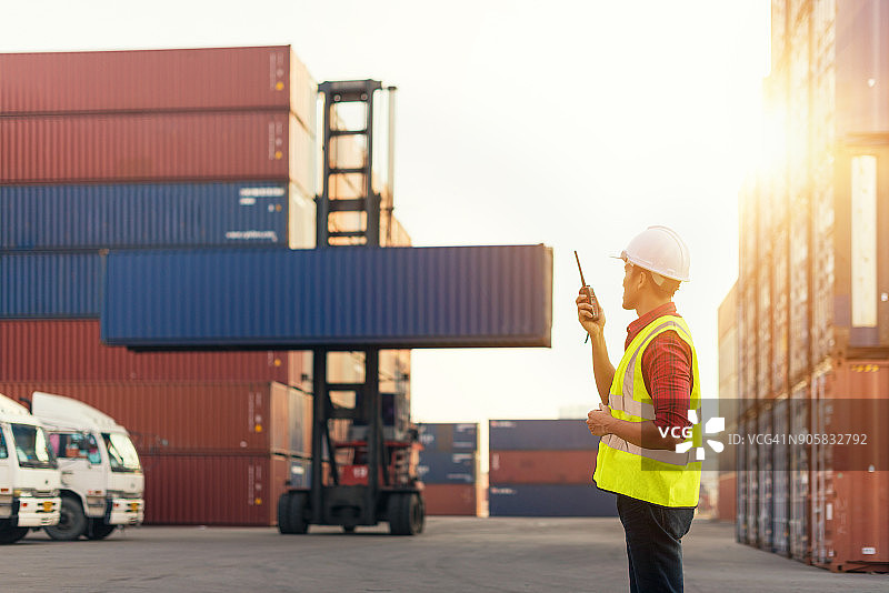 亚洲商业主管和工头秘书控制从货运卡车和集装箱船装载的集装箱，用于运输行业的进出口。工业概念。图片素材