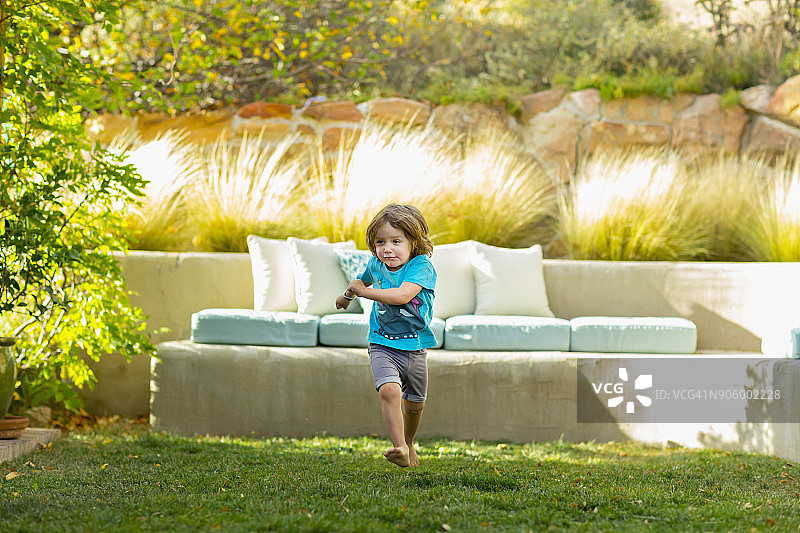 在后院奔跑的白人男孩图片素材