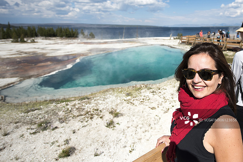 在黄石国家公园的间歇泉旁摆姿势的女性。美国怀俄明州图片素材