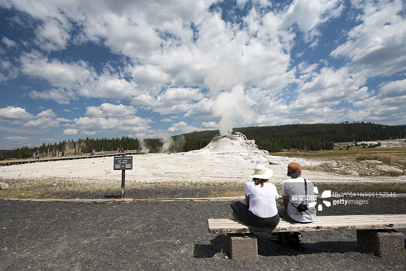 女子在美国怀俄明州黄石国家公园观看间歇泉的背影图片素材