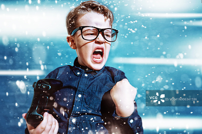 孩子用游戏控制器赢得比赛并欢呼图片素材