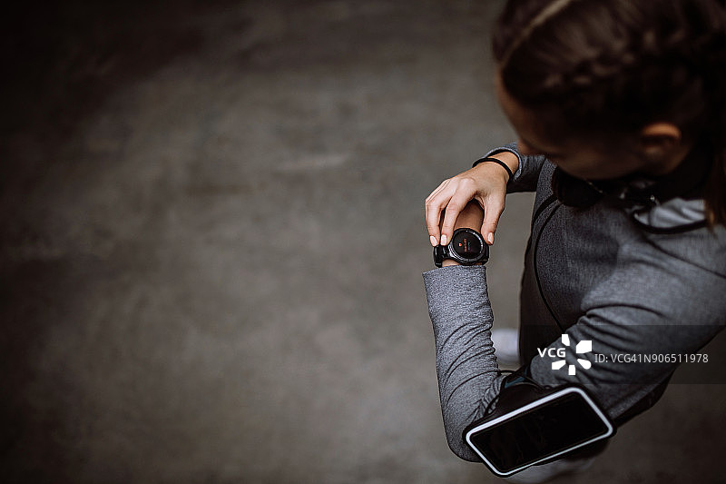 跑步女性看着智能手表心率监测器图片素材