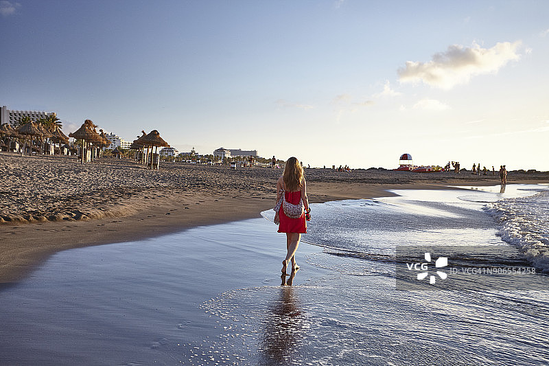 穿着红裙的女人在海滩上图片素材