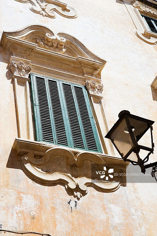 意大利莱切老城区巴洛克式窗框与路灯图片素材