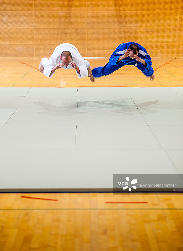 两名柔道运动员展示跳跃倒立技巧图片素材