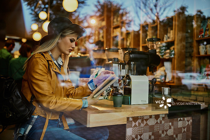 在咖啡馆看书的年轻女人图片素材