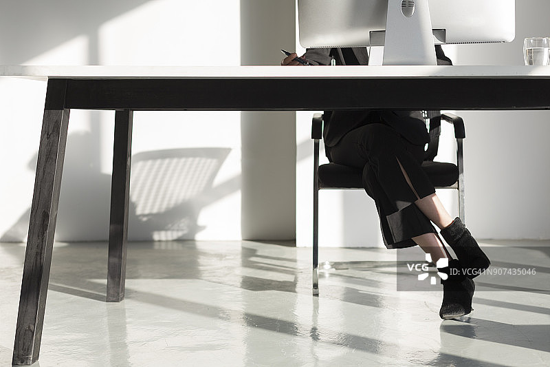 商务女性使用笔记本电脑工作的下半身图片素材