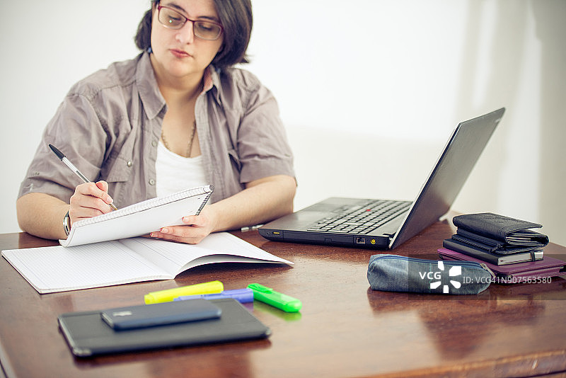 成年女人在办公室工作和做笔记图片素材