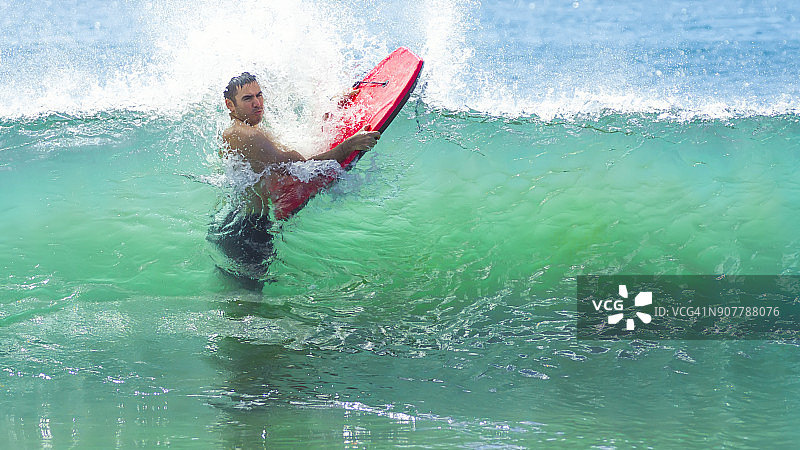 男子携带趴板冲浪图片素材