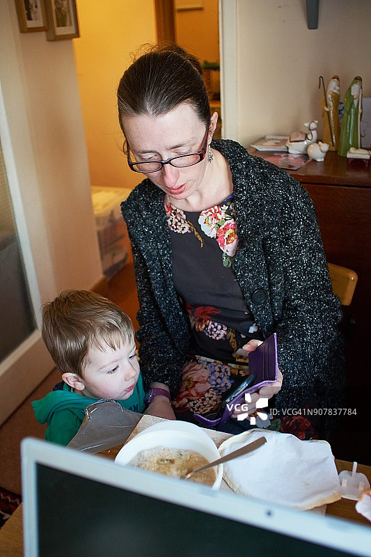 母亲在手机屏幕上与孩子分享照片图片素材