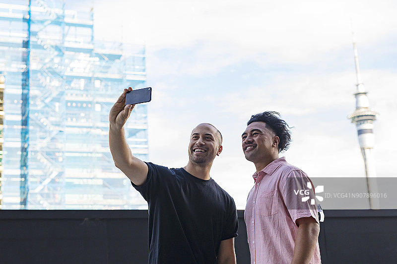 与奥克兰天空塔自拍的太平洋岛民男子图片素材