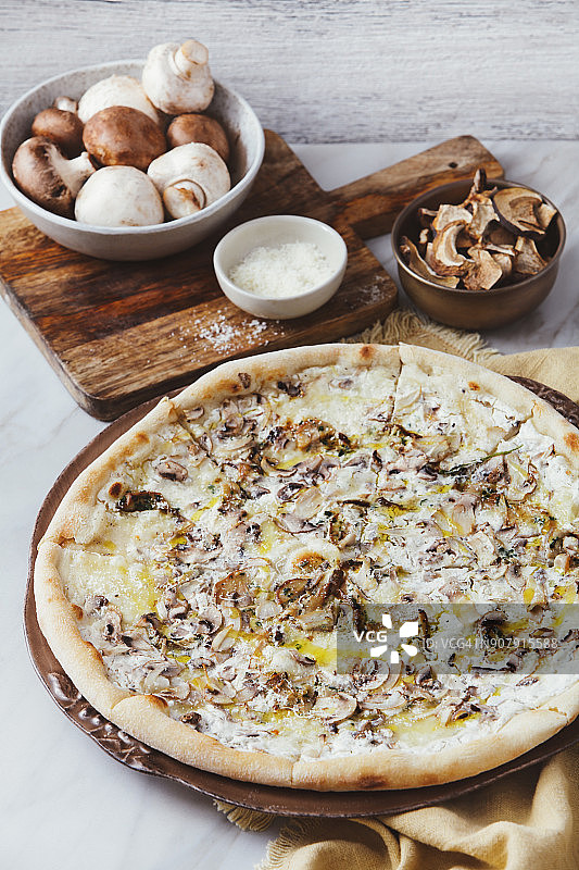 田野蘑菇、波尔奇尼蘑菇、马苏里拉奶酪和松露酱披萨图片素材