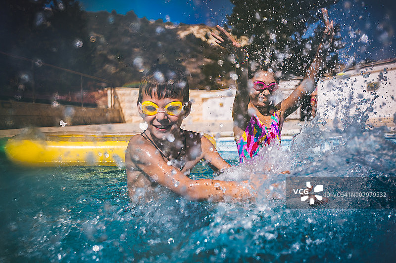 男孩和女孩在游泳池里玩水嬉戏图片素材