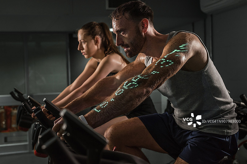 男人和女人在带有信息图表的健身车上锻炼图片素材