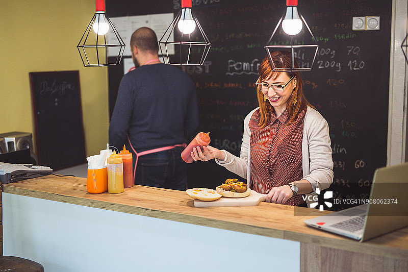 在美味的三明治上添加番茄酱图片素材