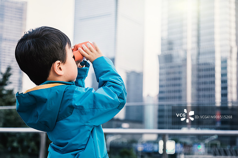 男孩在上海用望远镜观看图片素材