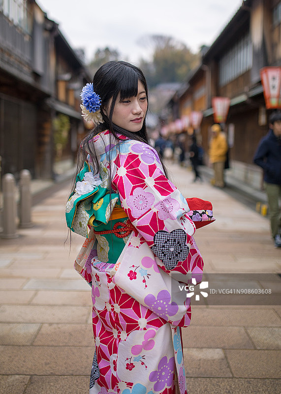 身穿和服的年轻女子在日本传统商业街回头图片素材